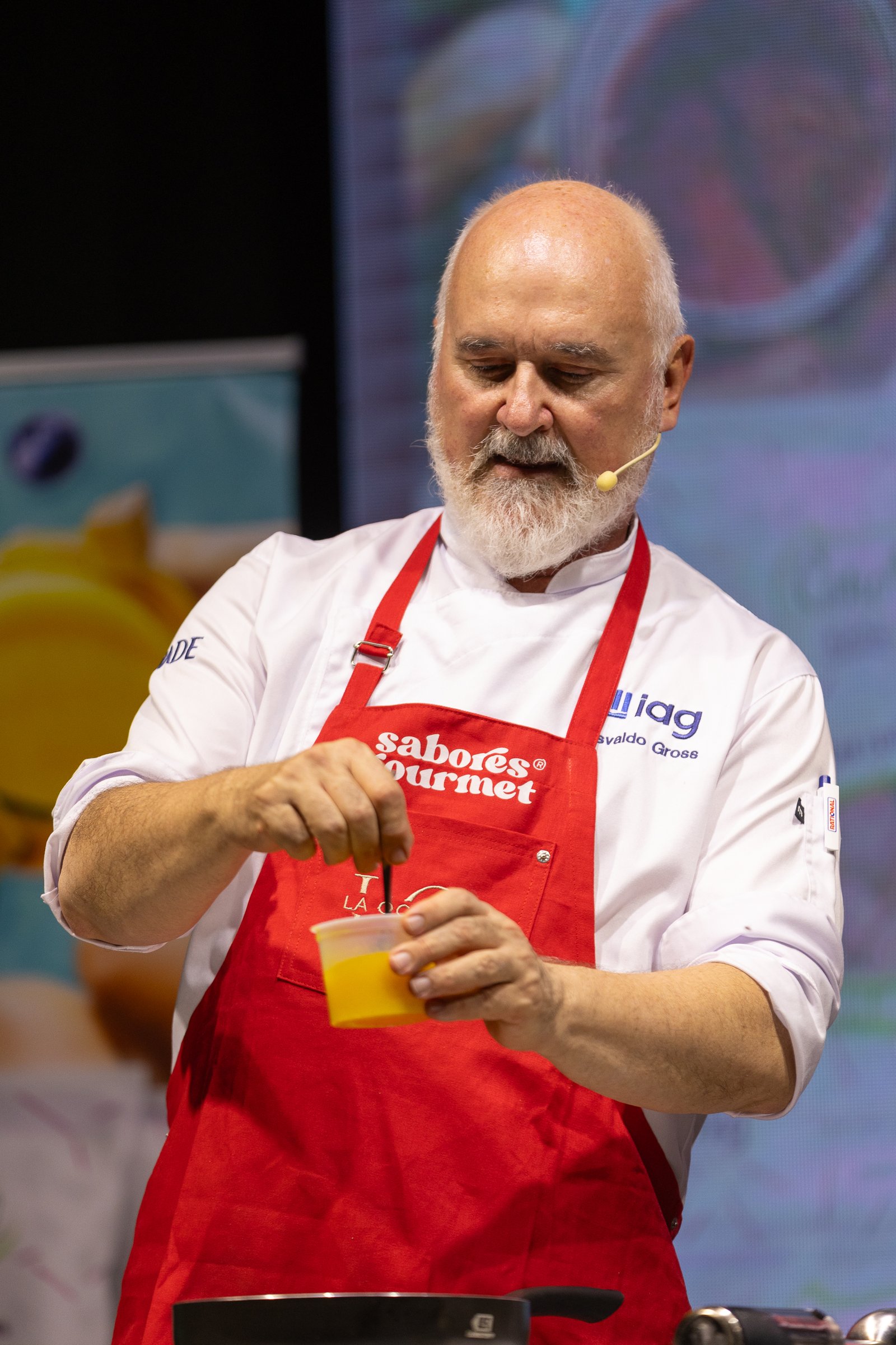 Osvaldo Gross dosificando un almíbar con delantal de Sabores Gourmet