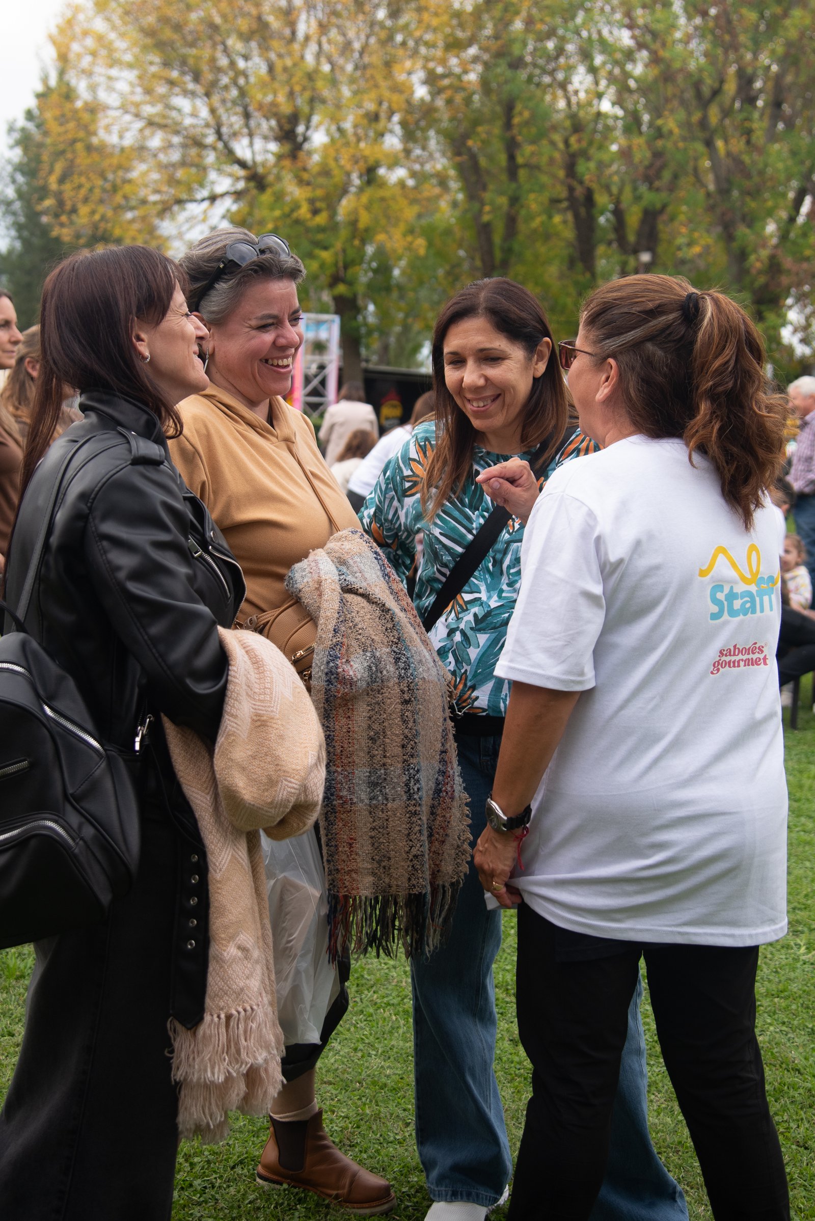Mujeres riendo y charlando junto a una integrante del staff de Sabores Gourmet