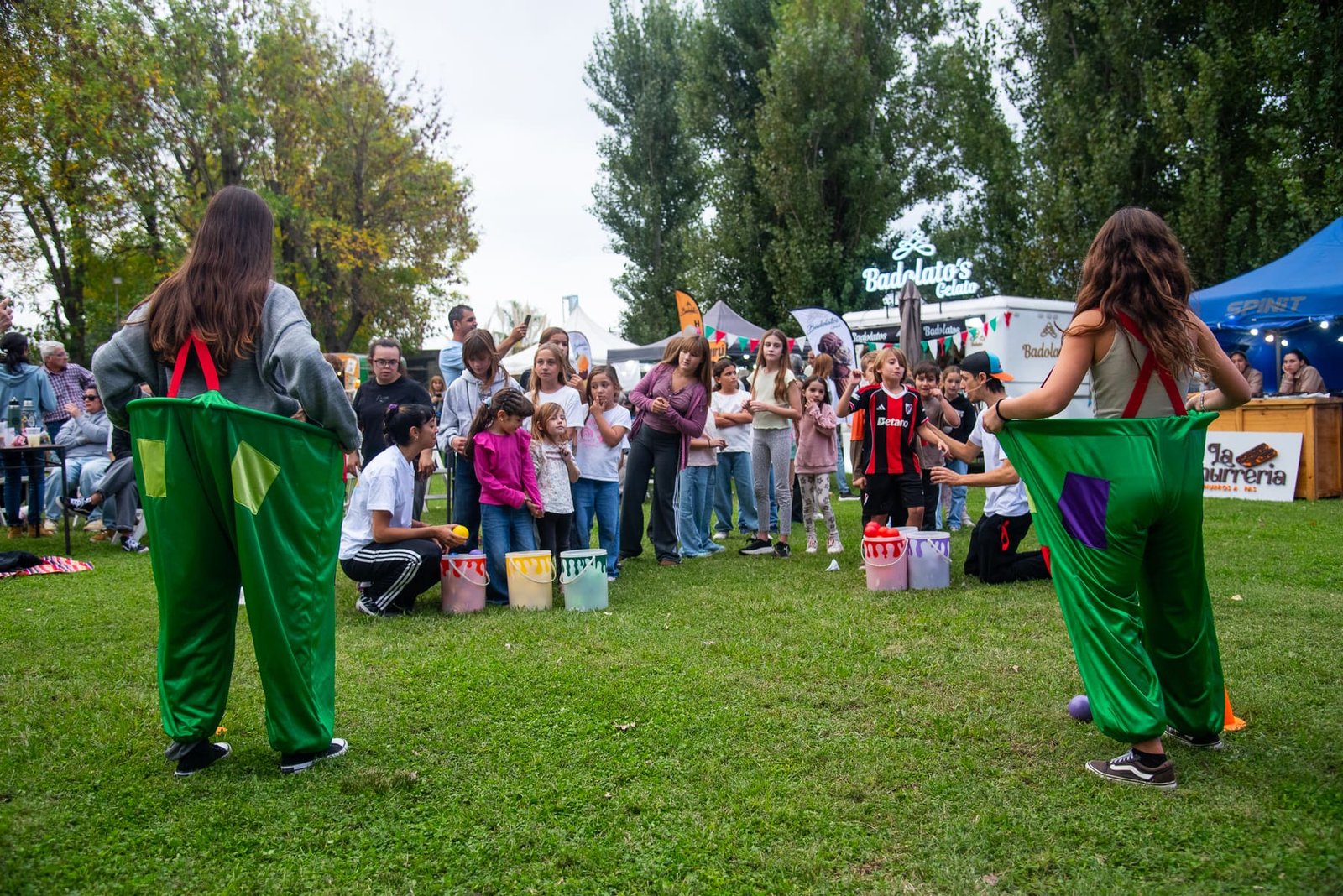Animadores con pantalones inflables jugando con chicos frente al público
