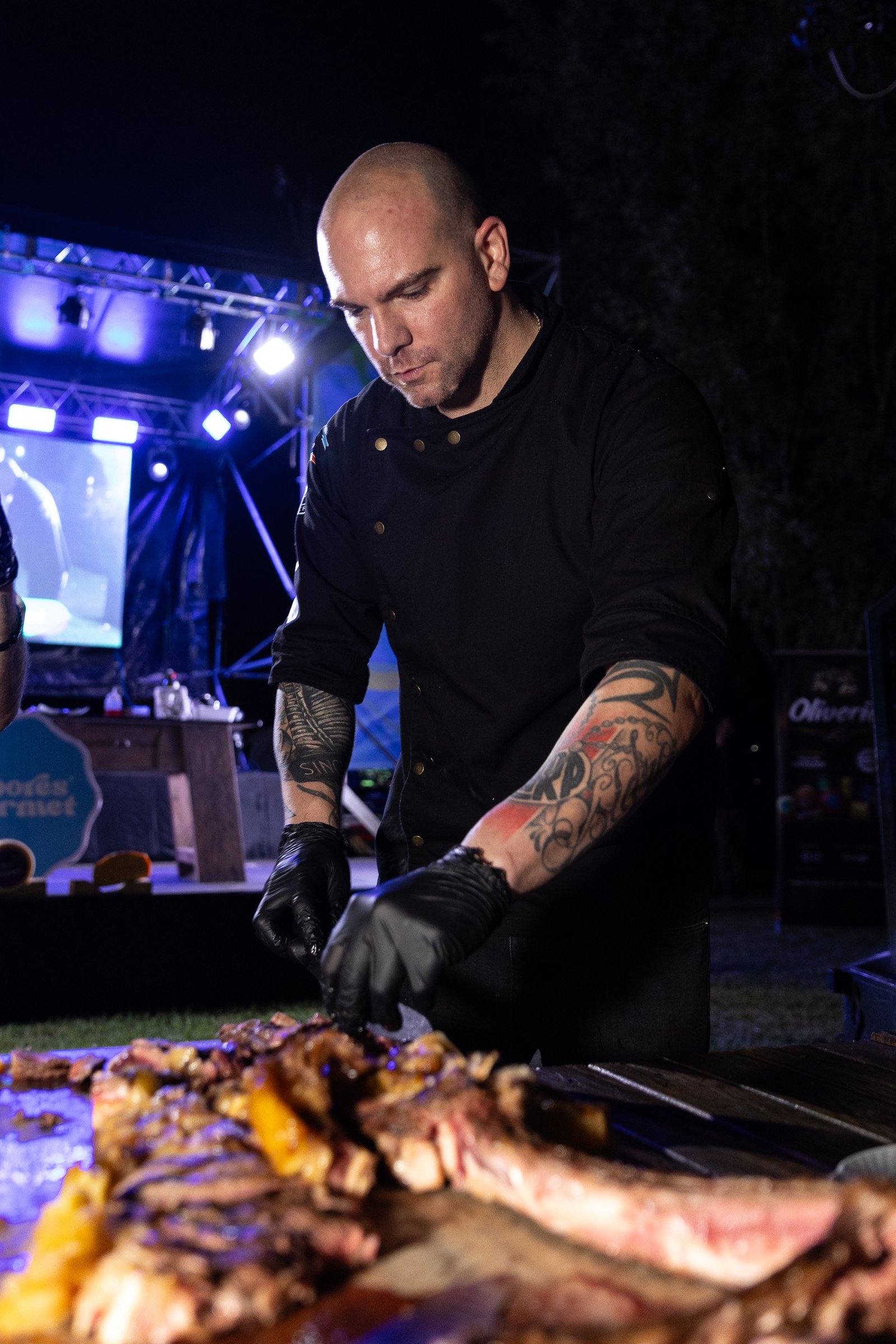 Chef cocinando junto a chispas y llamas frente a un cartel de Sabores Gourmet