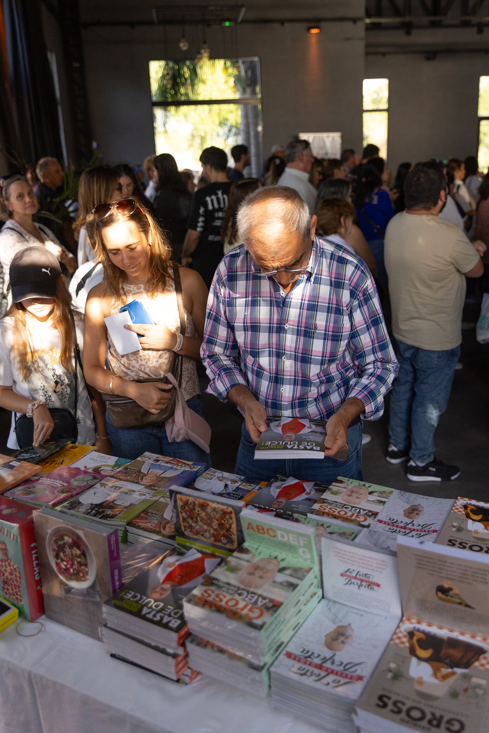 Señor mirando libros de cocina en un puesto de venta de libros